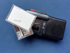 Ouderwetse mini bandrecorder met mini cassettes in doosjes: vertel je verhaal en tik hem uit. Voor als je moeite hebt met schrijven.